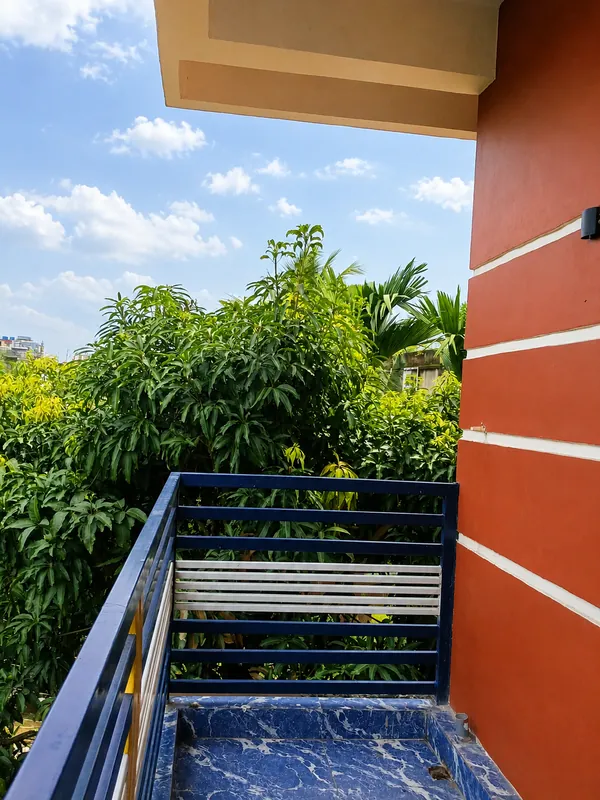 Nahor Suite balcony with blue railing overlooking mango and palm trees