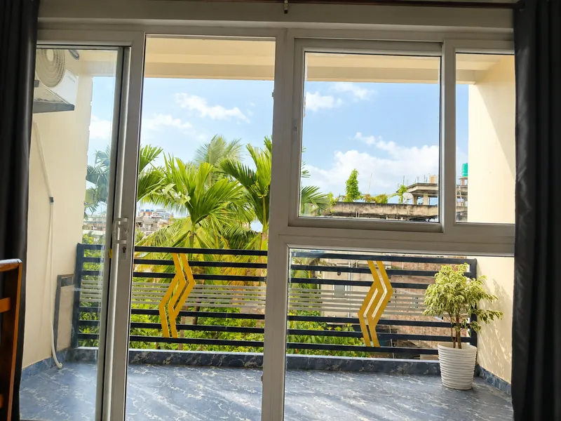 View through sliding doors to the Nahor Suite balcony and palm trees