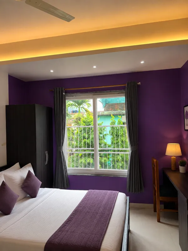 Simolu Suite second bedroom with purple wall and garden window